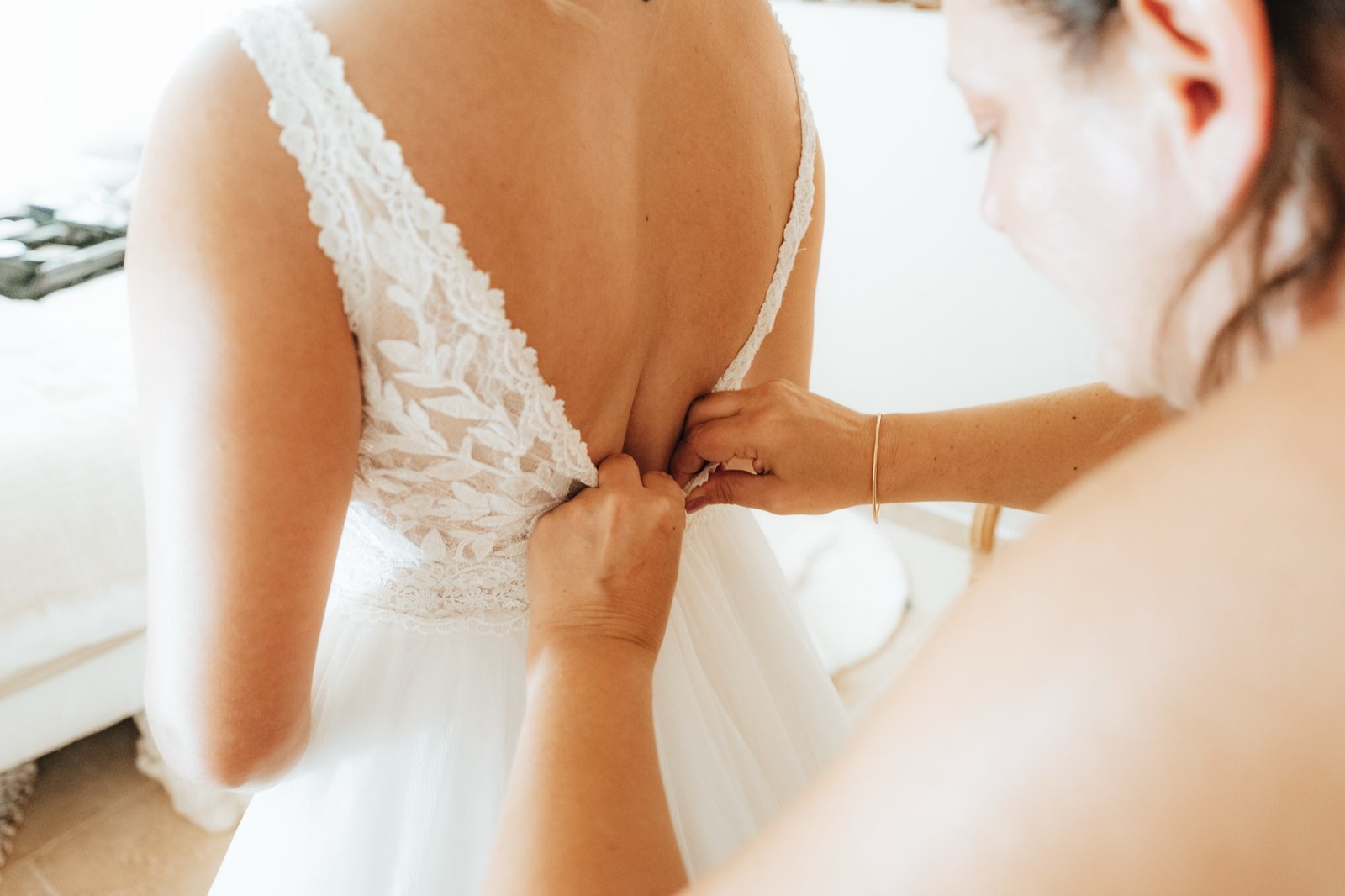 Une amie boutonne le dos de la robe de Fanny