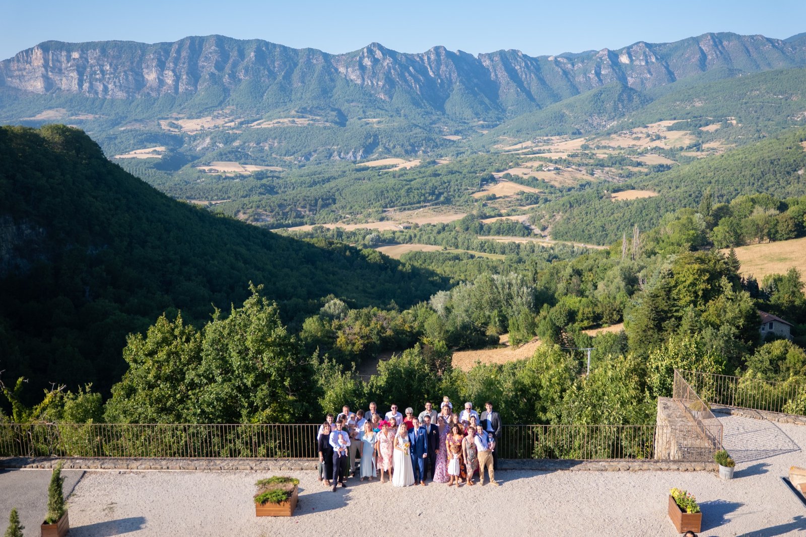 Tous les invités réunis sur une terrasse, face aux montagnes
