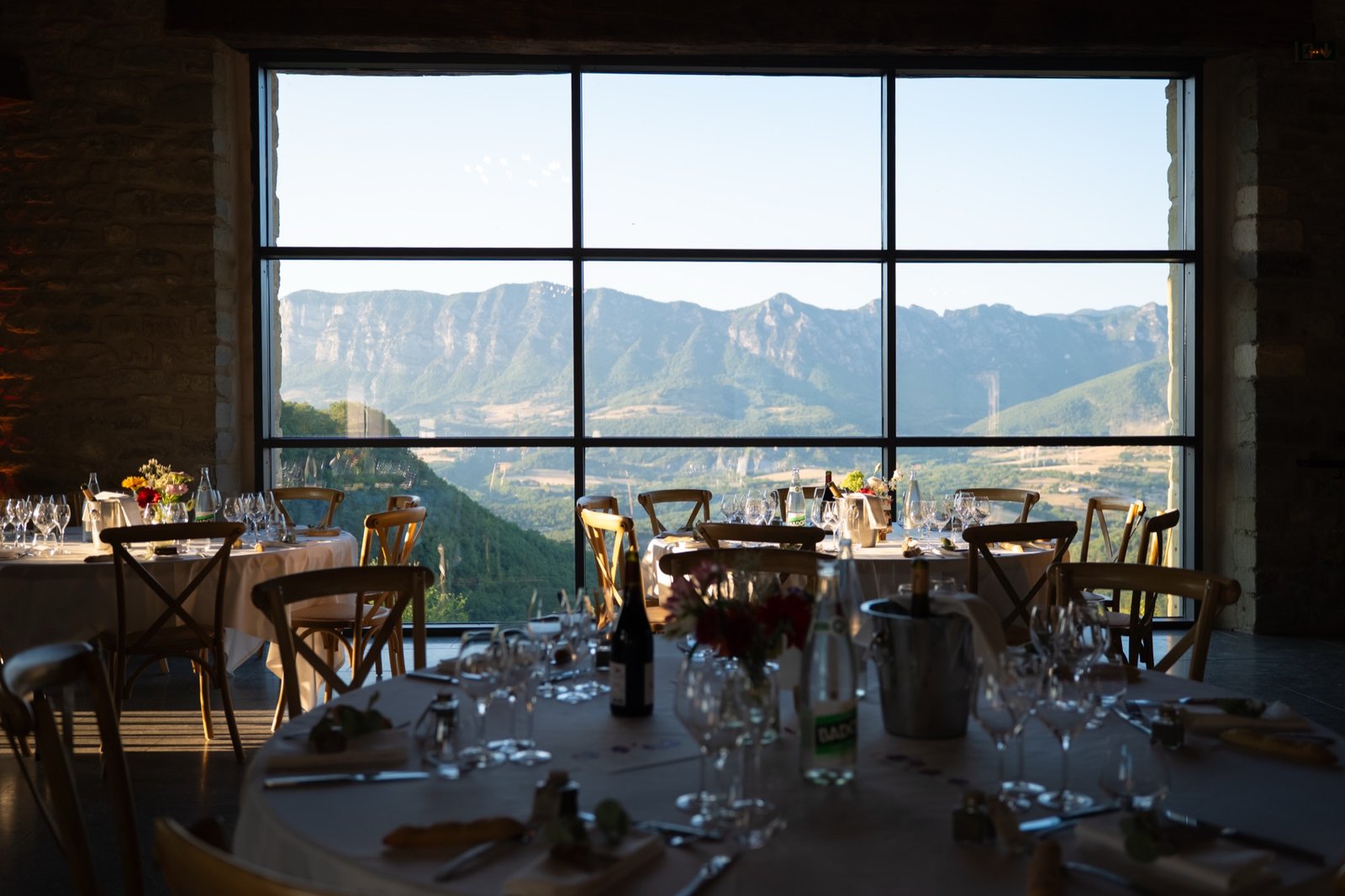 La salle dressée, sa grande baie vitrée ouverte sur les montagnes