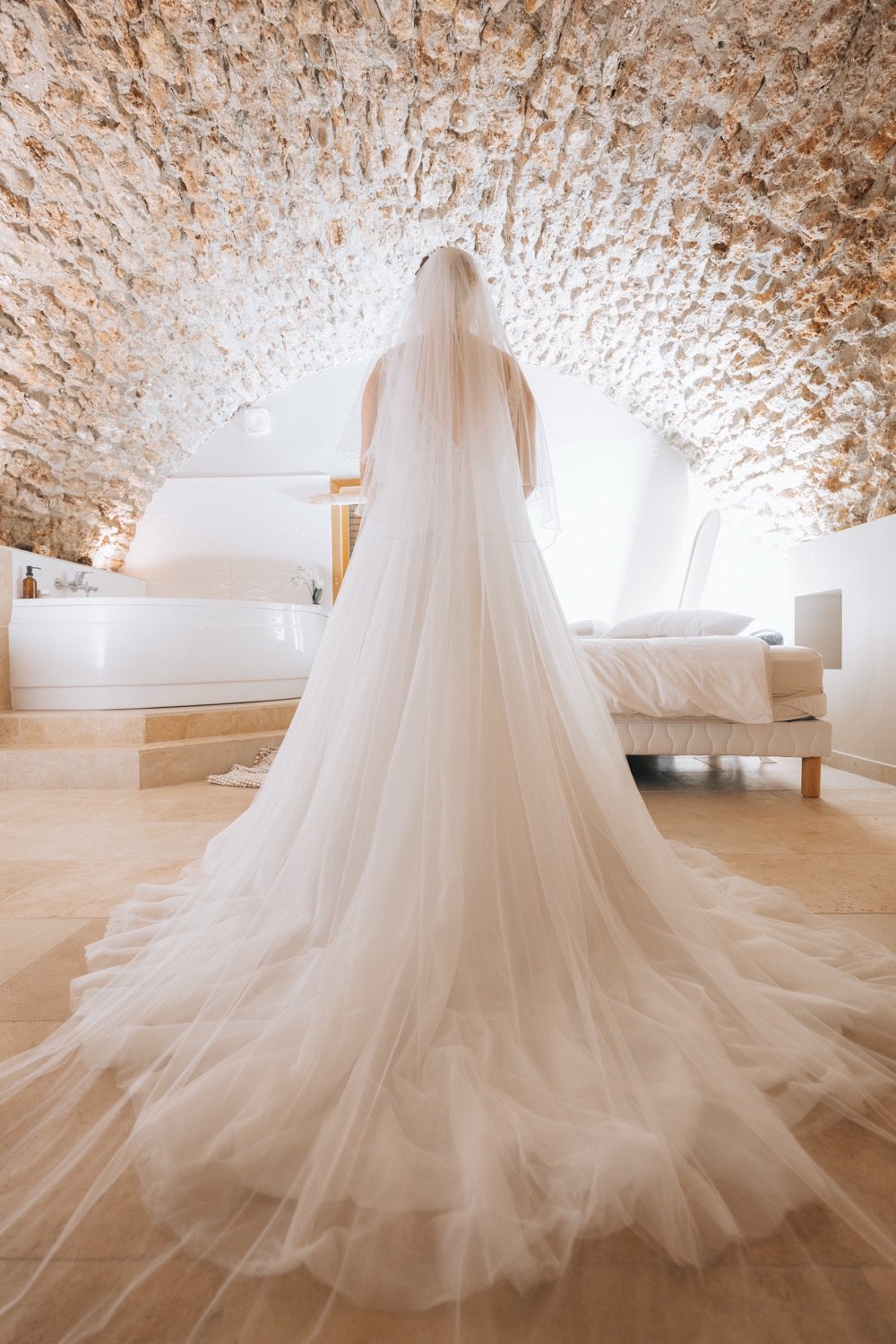 La robe de mariée sous une voûte de pierre