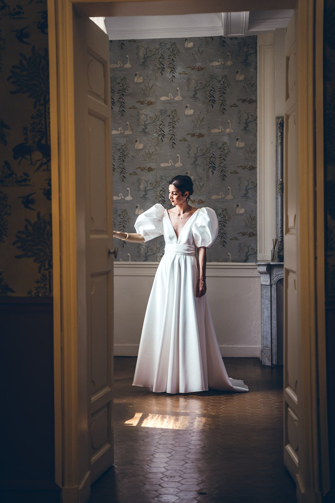 La mariée attend dans l'embrasure d'une porte