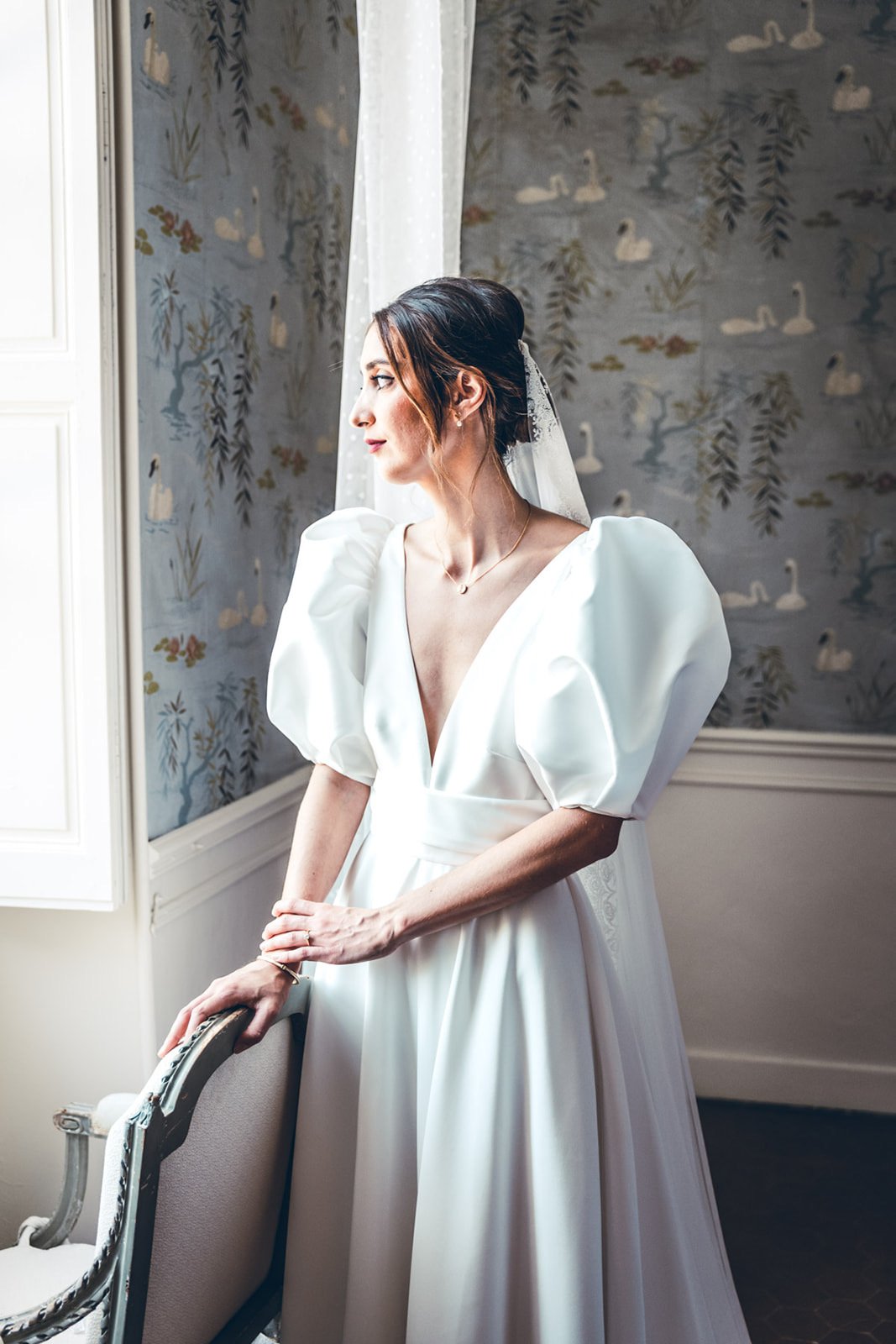 La mariée près d'une fenêtre, en lumière naturelle