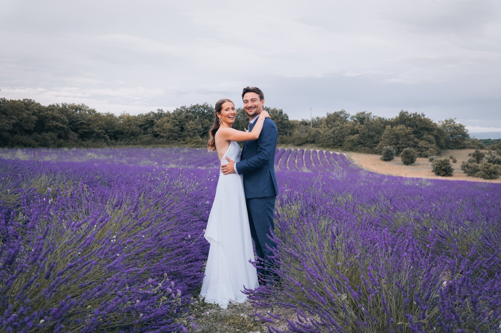 Mathilde et Hugo enlacés au milieu d'un champ de lavande, sous un ciel couvert
