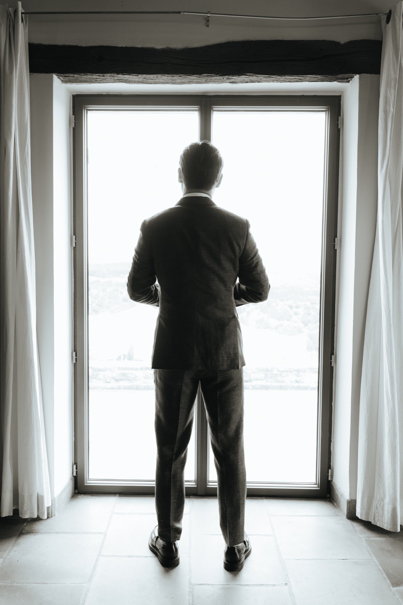 Hugo de dos, en silhouette devant une porte-fenêtre