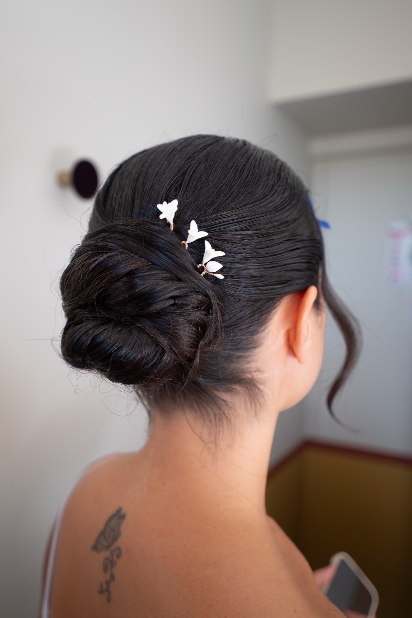 Le chignon de Pauline piqué de petites fleurs blanches