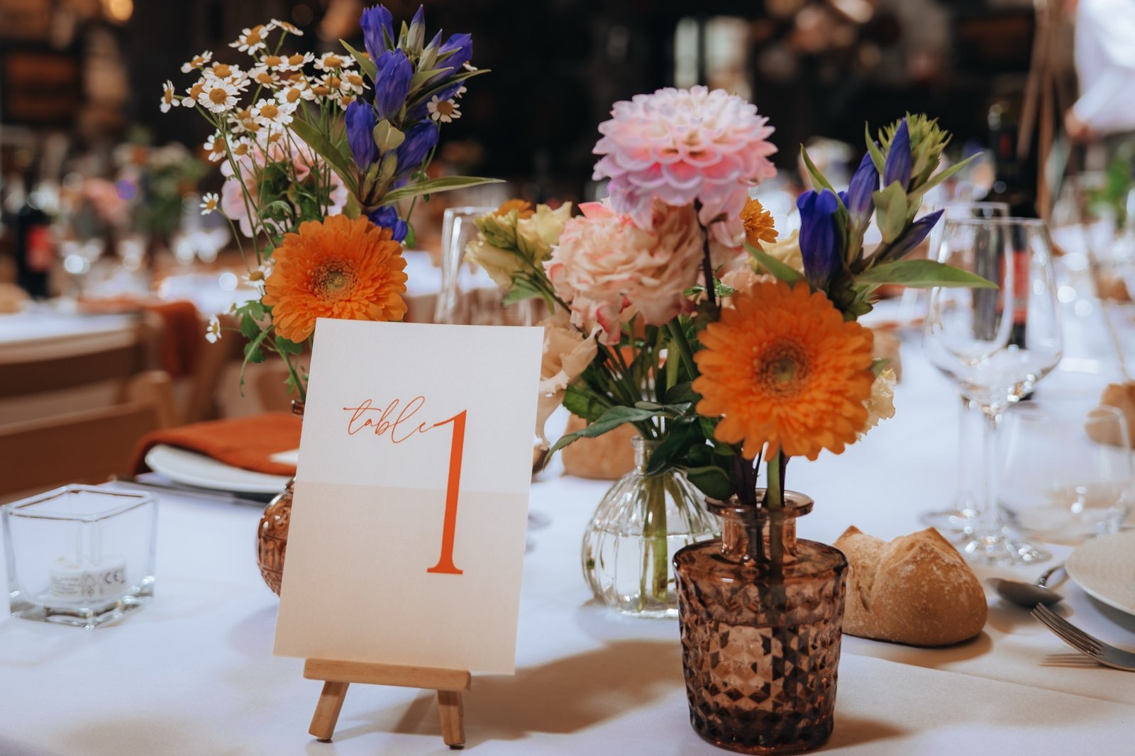 Un numéro de table et un bouquet de gerberas orange